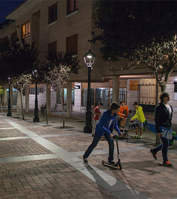 Άνθρωποι περπατούν βράδυ στους δρόμους της Palencia φωτισμένους με Philips lighting
