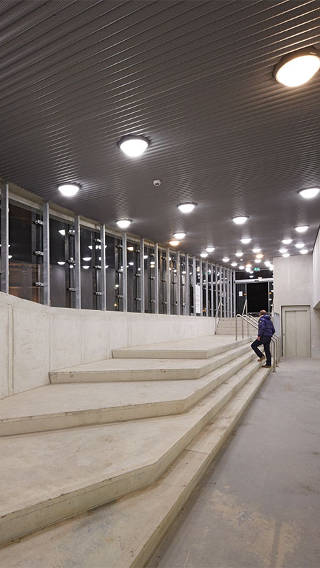  Άνδρας ανεβαίνει τα σκαλοπάτια στο χώρο στάθμευσης Eiteren φωτισμένο με Philips lighting 