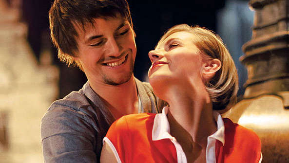 Χαρούμενο ζευγάρι σε μια πλατεία που αγκαλιάζεται με φωτισμό Philips