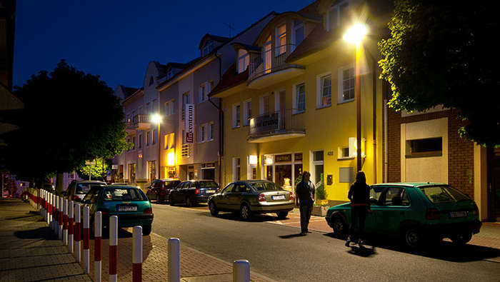 Άνθρωποι περπατούν στο δρόμο νύχτα με οδικό φωτισμό Philips 