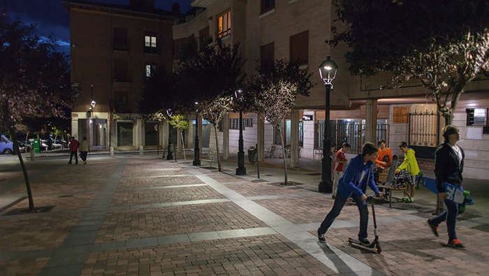 Παιδιά παίζουν σε μια πλατεία τη νύχτα με φωτισμό Philips