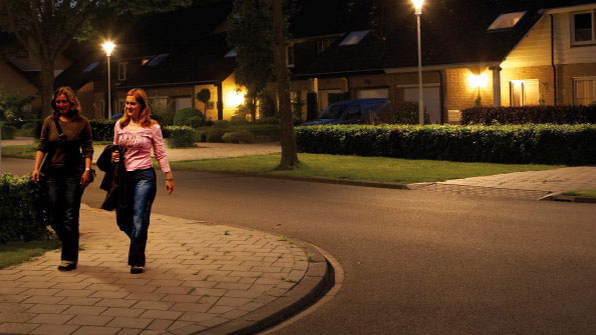 Δύο γυναίκες περπατούν σε ένα δρόμο που φωτίζεται με λευκό φωτισμό της Philips