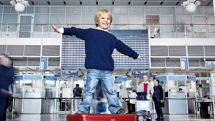 Χαρούμενο παιδί σε τερματικό σταθμό αεροδρομίου